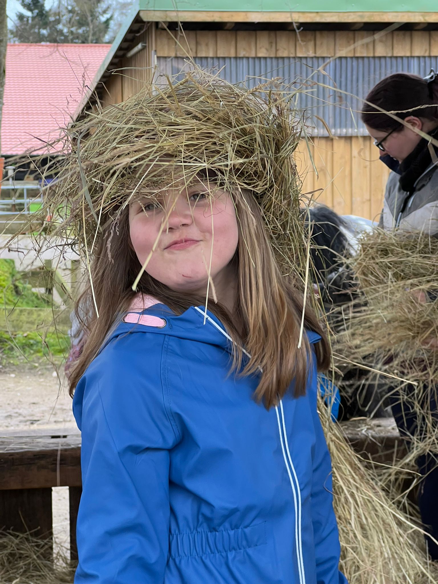 Fröhliches Kind mit Stroh auf dem Kopf